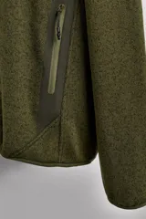 Chaqueta verde militar de punto con interior de polar. Tiene cuello alto, manga larga con bolsillo con cierre en la manga, bolsillos laterales con cierre y cierre frontal con cremallera.