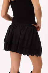 Minifalda marrón con volados de broderie, cintura elastizada con cordón ajustable y detalle de cuentas de madera.