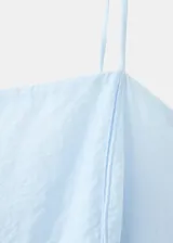 Vestido midi celeste de tirantes finos, con escote cuadrado y costuras verticales decorativas. Confeccionado en mezcla de lyocell y poliamida, con forro interior de algodón.