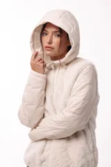 Campera con capucha, cuerpo de pelo sintético y mangas matelaseadas con cierre frontal.