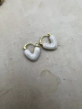 Set de aros tipo argolla con forma de corazón esmaltados en diferentes colores: marrón, blanco, lila y bordó. El cierre es de tipo clip.