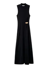 Vestido largo negro de corte recto, con cuello alto, manga larga y detalle de broche metálico dorado en la cintura.