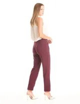 Pantalón de corte recto confeccionado en crepe, con cintura alta y detalle de botones metálicos dorados decorativos en los laterales. Presenta una silueta estructurada y elegante.