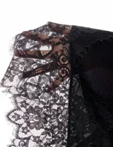 Pollera midi asimétrica de color negro, confeccionada en tejido liviano con caída fluida. Presenta un diseño con transparencias y detalles de encaje en el ruedo, con una abertura lateral que aporta movimiento.