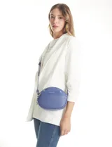 Cartera tipo bandolera de eco cuero con silueta de media luna, color beige y detalles en marrón claro. Incluye un monedero/tarjetero independiente en el bolsillo frontal y una cadena decorativa de eslabones dorados.