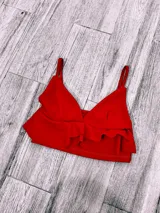 Top color rosa con breteles finos, escote en V y doble volado en el ruedo.