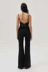 Top negro de lurex con tirantes finos regulables, volados en el frente y lazos en la espalda.