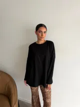 Conjunto de dos piezas compuesto por un buzo de cuello redondo y mangas largas con diseño holgado y un pantalón de corte recto y tiro alto. Ambas prendas están confeccionadas en tejido de punto acanalado.