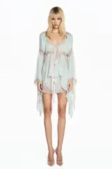 Bata de chiffon color verde agua con mangas largas acampanadas y detalles de encaje en tono beige. Presenta un diseño fluido, semitransparente, con lazo frontal para anudar y terminaciones delicadas.