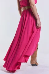 Pollera larga fucsia con corte irregular y cintura elastizada.