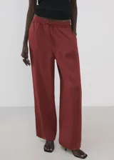 Pantalón palazzo largo de tiro alto, color bordó, con cintura elástica y lazo ajustable.