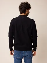 Sweater de punto color negro, con cuello alto y cierre frontal parcial tipo medio cierre. Presenta textura en el tejido y logo bordado en el pecho.