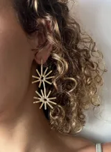 Par de aros colgantes de metal dorado con forma de sol. Cada aro tiene dos soles, uno más pequeño arriba y otro más grande abajo.