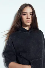 Buzo canguro color marrón oscuro con efecto lavado, calce relajado, capucha integrada, bolsillo frontal tipo canguro y terminaciones clásicas en puños y ruedo.