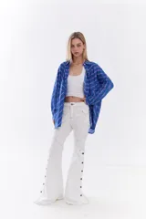 Camisa oversize azul de algodón con rayas horizontales y verticales en tonos violeta y verde, corte holgado y diseño con recortes.