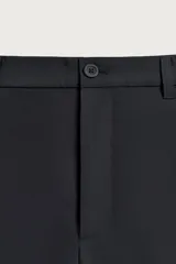 Pantalón regular fit color negro de corte recto, con cintura elástica en los laterales, trabillas, bolsillos frontales y cierre con botón y cremallera.