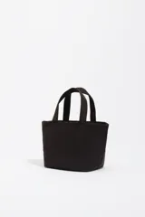 Bolso mini de diseño compacto confeccionado en nylon, con asa de mano y cierre de cremallera. Presenta el logo de la marca bordado en la parte frontal con hilos de colores.