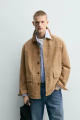Chaqueta relaxed fit de piel con acabado serraje en color tostado, con cuello de solapa combinado a contraste, bolsillos de plastrón con solapa en la cadera y cierre frontal de botonadura.