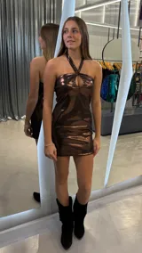 Vestido corto de fiesta en tejido metalizado color chocolate, con escote halter y abertura tipo gota en el centro del pecho.