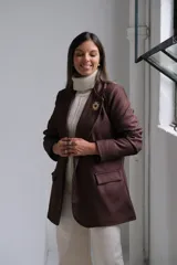 Blazer de corte sastrero en color marrón chocolate, con solapas clásicas, bolsillos delanteros con solapa y costuras a la vista en tono contrastante.