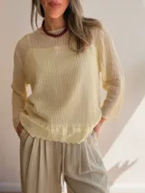 Sweater de punto calado color rosado, con diseño holgado, cuello redondo y mangas largas, que incluye una musculosa interior con terminación bordada en el bajo.