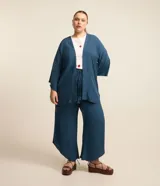 Pantalón pantacourt plus size de viscosa color azul, con cintura elástica y cordón de ajuste con borlas. Presenta un diseño fluido y dobladillo asimétrico.