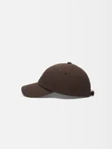 Gorra de visera marrón con el logotipo de Jacquemus en letras metálicas plateadas en la parte frontal y visera pespunteada.
