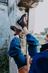 Botas de cuero color marrón chocolate con suela de goma tipo track en color negro. Presentan un diseño de caña media con cierre frontal metálico y costuras reforzadas.