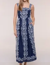 Vestido midi azul marino con bordados florales blancos, escote cuadrado, breteles anchos y falda amplia con bolsillos.