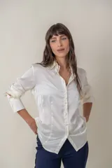 Camisa de seda con acabado satinado, de corte holgado y manga larga con puños anchos. Presenta cuello clásico y cierre frontal con botones al tono.