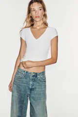 Jeans de tiro medio y corte balloon color azul, con trabillas, bolsillos delanteros y traseros, y cierre frontal con cremallera y botón metálico.