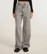 Pantalón wide leg de jeans gris lavado, tiro alto, con bolsillos delanteros y traseros, cierre con botón y cremallera.