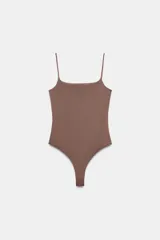 Body de corte ajustado con escote recto y tirantes finos ajustables. Presenta cierre inferior con botones a presión.