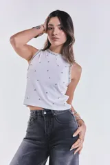 Musculosa blanca de tejido acanalado, sin mangas, con cuello redondo y aplicaciones de strass y tachas en el cuello y sisas.