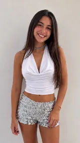 Top halter blanco con escote drapeado y diseño ajustado al cuerpo.