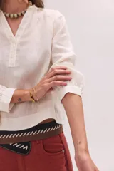 Blusa de lino color marrón con cuello mao, escote en V y mangas largas.