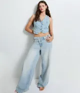 Chaleco de jean con escote en V, cierre frontal con botones metálicos y ruedo redondeado. Presenta un diseño clásico con lazo ajustable en la espalda.
