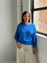 Sweater de punto color azul vibrante, con diseño de textura acanalada vertical en el frente, cuello redondo y mangas murciélago con puños ajustados.