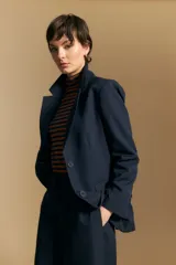 Blazer de corte sastrero con solapas clásicas y estructura definida. Presenta un diseño versátil con silueta ligeramente oversized, ideal para un estilo sofisticado y atemporal.