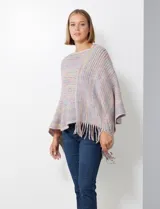 Poncho tejido en hilo soft, con efecto jaspeado multicolor (predominantemente tonos oscuros como azul marino, negro, y toques de violeta y dorado/lurex). Presenta un diseño asimétrico y flecos largos en los bordes.