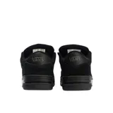 Championes Vans modelo Hylane Mono de perfil bajo y diseño voluminoso, confeccionados en gamuza negra con acabado texturizado. Presentan lengüeta sobredimensionada, cuello acolchado y la clásica banda lateral de la marca en tono sobre tono.