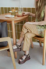 Sandalias de plataforma color negro, con diseño de dos tiras anchas en el empeine y cierre con velcro en el tobillo. Presentan una suela de plataforma alta y liviana.