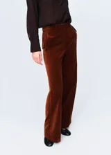 Pantalón de corte recto y tiro medio confeccionado en tejido de terciopelo. Cuenta con bolsillos laterales, bolsillos de ribete en la parte posterior, trabillas para cinturón y cierre oculto con botón, gancho y cremallera.