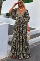 Vestido largo verde con estampado paisley, escote en V profundo, mangas amplias con volados y corte imperio con detalles bordados.