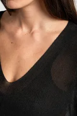 Sweater de punto con acabado brillante, cuello en V y mangas tres cuartos. Presenta un diseño holgado y tejido traslúcido.