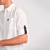 Camisa de manga larga convertible, color blanco, confeccionada en popelina. Cuenta con cuello clásico, cierre frontal con botones, bolsillo en el pecho con etiqueta de marca y mangas enrollables con pestaña de ajuste.