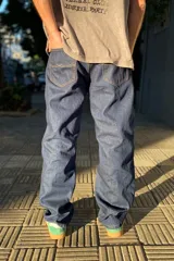 Pantalón de jean azul oscuro con corte baggy y calce relajado. Presenta cinco bolsillos clásicos y costuras reforzadas en tono contrastante.