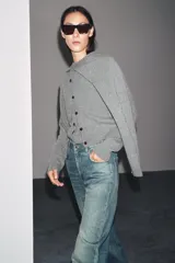 Chaqueta de tejido de punto color verde musgo, de corte cropped, con cuello redondo y cierre frontal de botones oscuros.