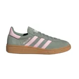 Championes adidas Handball Spezial de gamuza en color verde oliva con las icónicas tres tiras y detalle en el talón en color rosa pastel. Presenta suela de goma color caramelo y el nombre del modelo grabado en el lateral.