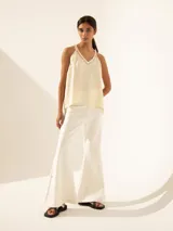 Top negro de viscosa sin mangas, con breteles finos y apliques de strass en breteles y escote.